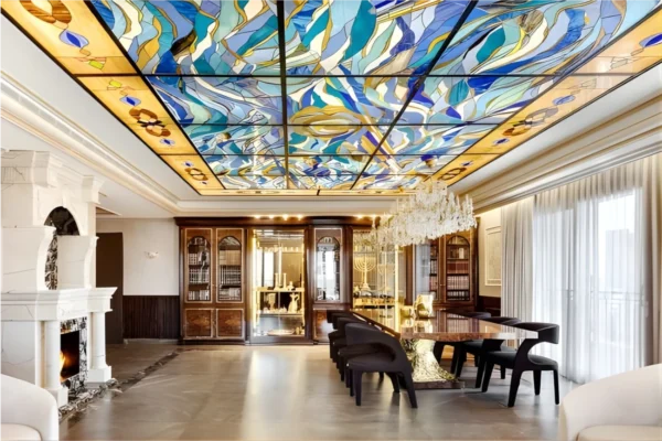 תקרת ויטראז' ,זכוכית מחוסמת בבית יוקרה בירושליים,מנורות קודש מרהיבות מזהב בויטרינות וספרים שולחן אוכל אח בוער ,נברשות אור מעל שולחן האוכל.