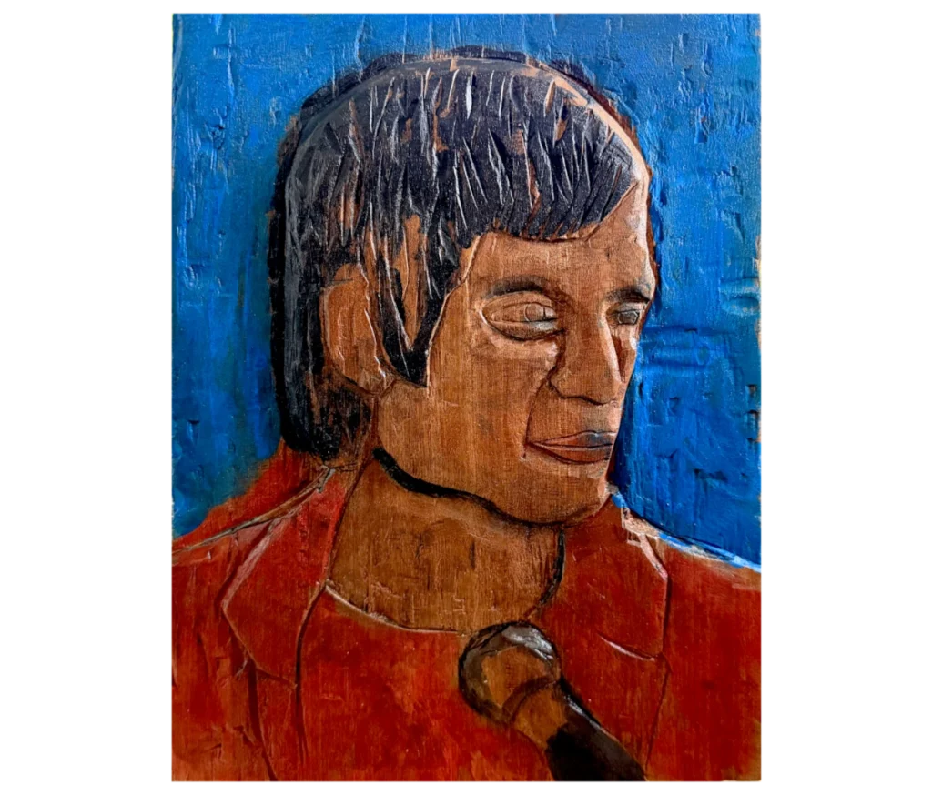 דיוקן מגולף מעץ מהגוני של אריק איינשטיין, בסגנון מופשט ואקספרסיבי, המתאר אותו מהכתפיים ומעלה עם מיקרופון מולו ורקע כחול.